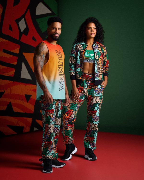 Male and female models wear colorful Zumba print joggers; he pairs with ombré tank, she with bra top and jacket against a colorful background.