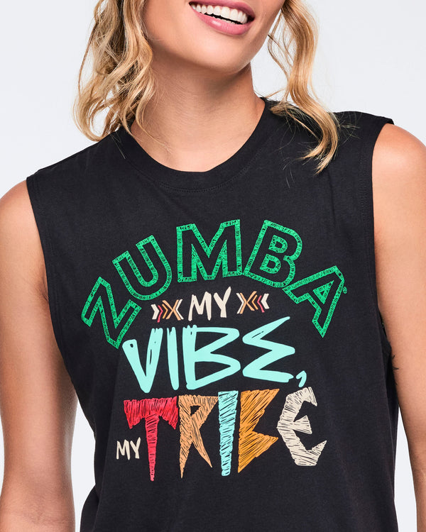 Close-up of a black sleeveless Zumba tank top with a crew neckline and multicolor “Zumba My Vibe, My Tribe” graphic across the front. Female model wears the top in a cropped chest-up view showing the bold printed design.