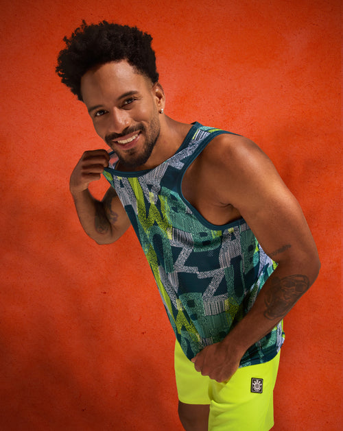 Studio banner of a male model posing against a textured orange background, wearing a basketball style tank with bright neon yellow shorts.