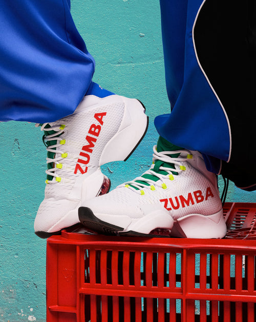Close-up product banner featuring white high-top sneakers perched on a red crate against a teal wall.