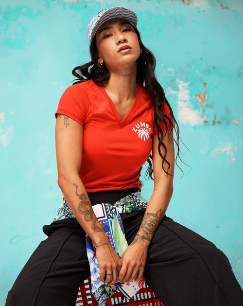 Banner set against a distressed teal wall, featuring a female model seated on a red crate