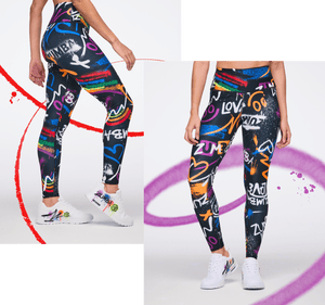 Female model showcasing graffiti‑print leggings in bold multicolor designs against a white backdrop with vivid paint strokes.