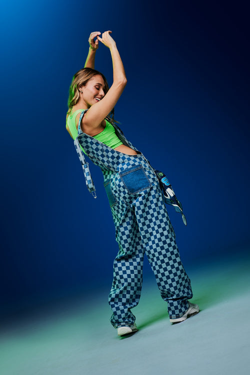 Shop this look grid image of a female model wearing a green crop tank and blue checkered overalls against a blue background.