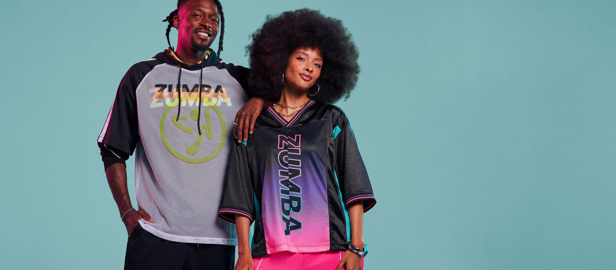 Male and female models standing on an aqua background, wearing a white mesh Zumbito hoodie and a black-to-pink gradient 