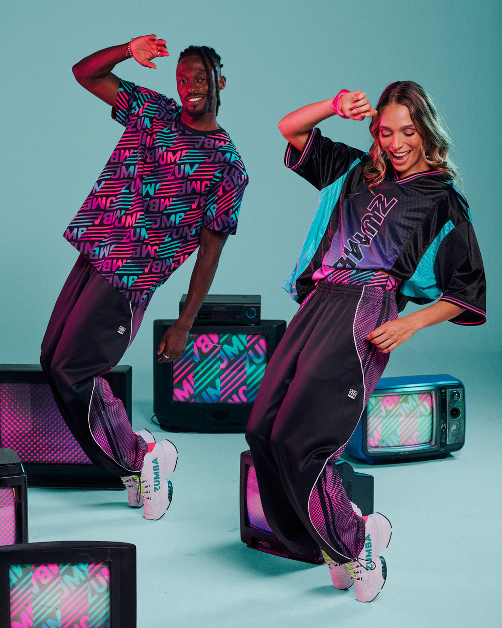 Male and female models dancing against an aqua background surrounded by vintage TVs, wearing colorful striped and gradient 
