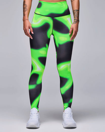 Neon green and black swirl print leggings on a female model, showing the high, smooth waistband and fitted ankle-length legs.