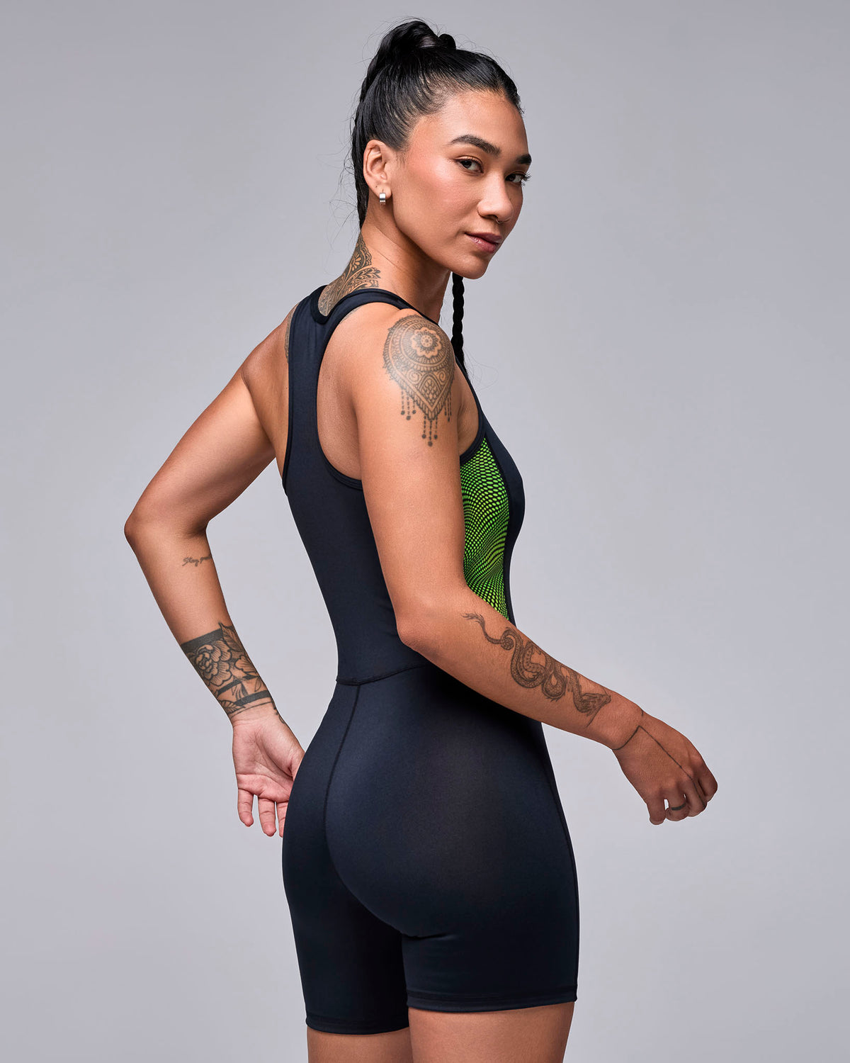 Shown from the back, the black biker bodysuit with a racerback, the wavy check print side panel, and a smooth fit through the seat.