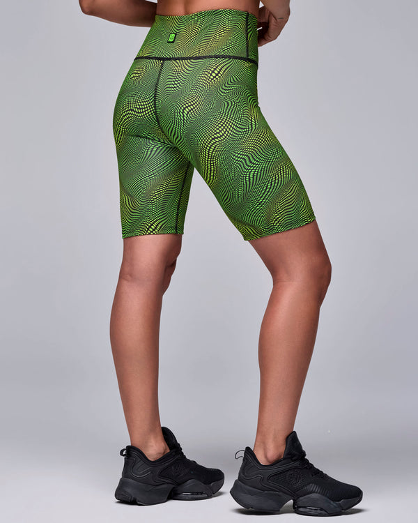Shown from the back, the wavy check print biker shorts, with a small neon green logo tag at the back waistband.