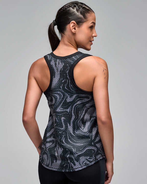 Back view of a black and gray swirl-print mesh tank top with black trim and a racerback silhouette. Female model wears the sleeveless athletic tank with black fitted biker shorts against a light gray background.