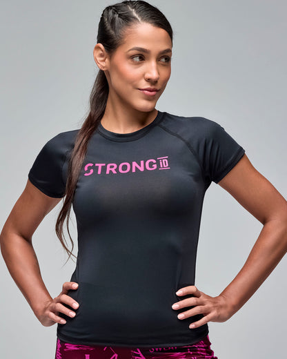 Black fitted short-sleeve performance top with bright pink “STRONG iD” text on the chest. Female model wears the crewneck athletic tee with burgundy and pink printed leggings in a front view against a light gray background.
