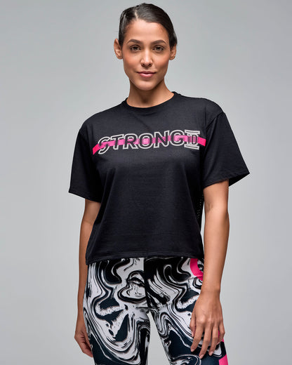 Black cropped short-sleeve T-shirt with white outlined “STRONG iD” text and a bright pink stripe across the chest. Female model wears the loose crewneck tee with white and black swirl-print leggings against a light gray background.