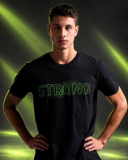 Male model in a black crew neck tee with neon green outlined 'STRONG' text over a green wave-like graphic across the chest, against neon light beams.