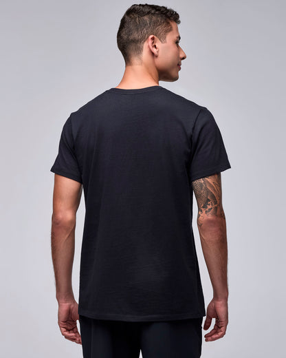 Back view of the black unisex 'STRONG' tee on a male model, showing a plain back and short sleeves.