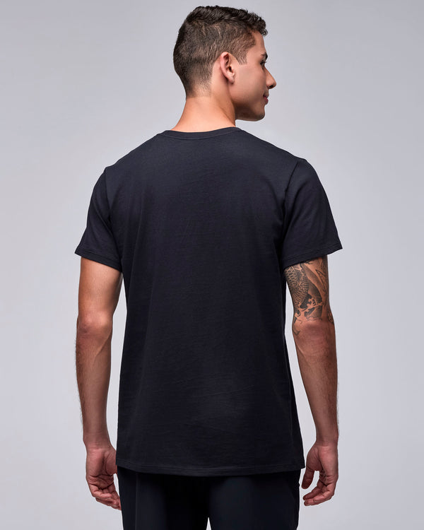Back view of the black unisex 'STRONG' tee on a male model, showing a plain back and short sleeves.