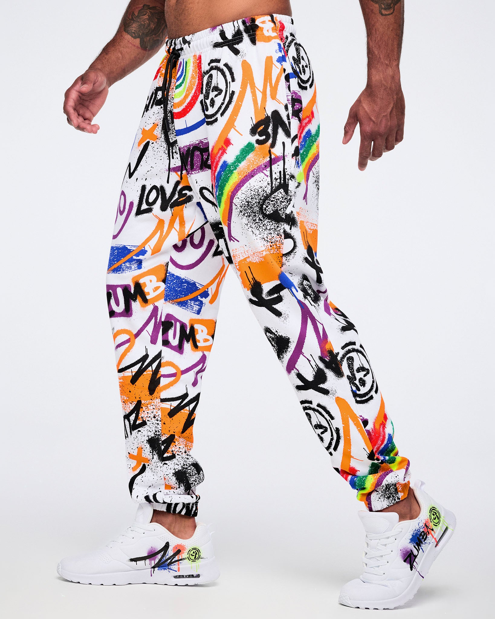 Colorful graffiti-style pants worn by a male model on a white background.