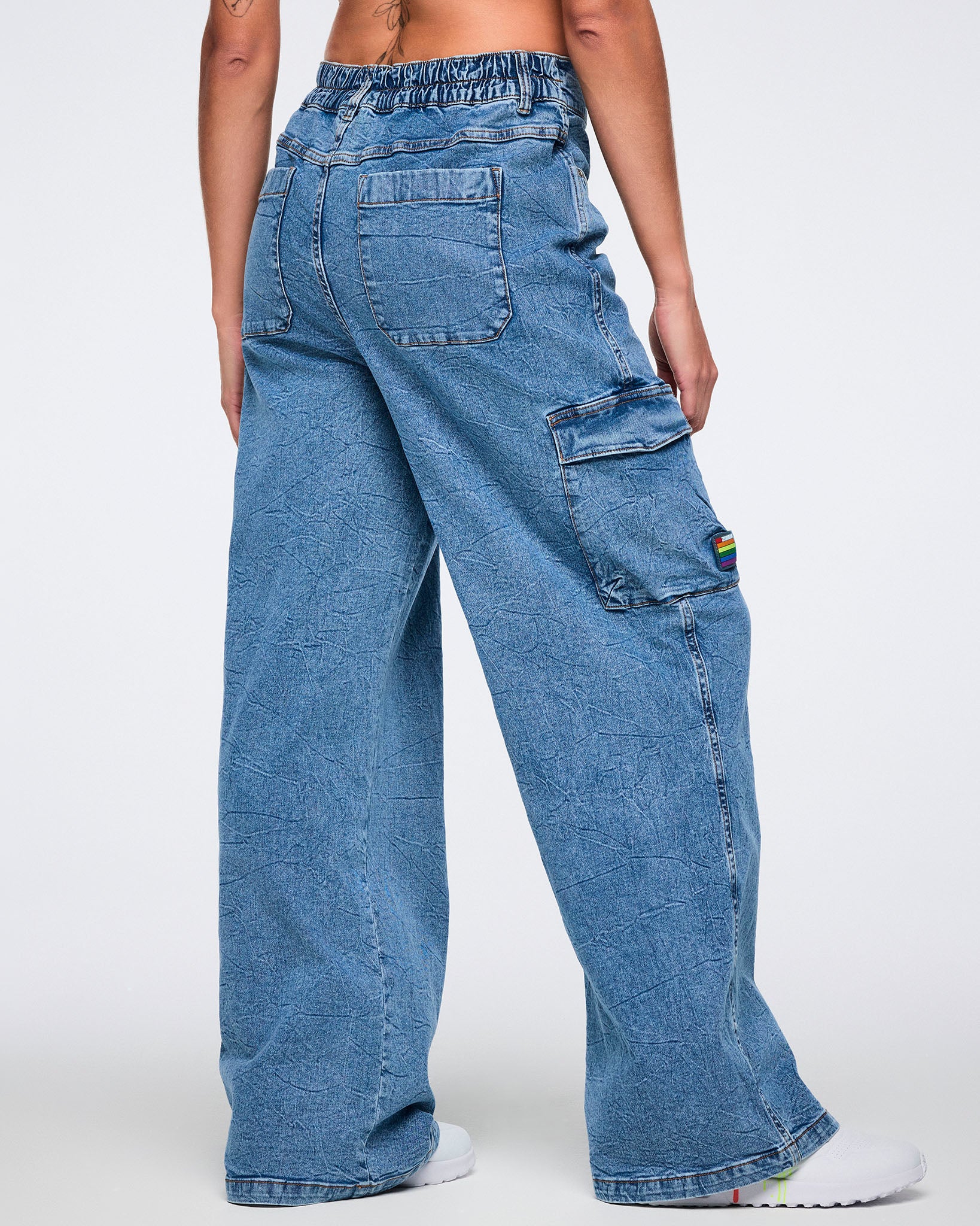 Female model shown from the back wearing denim cargo pants with visible back pockets and side cargo pocket against a white background.