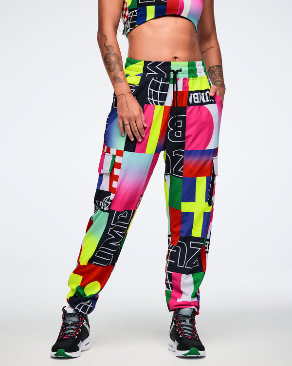 Female model wearing colorful, patterned pants on a white background.