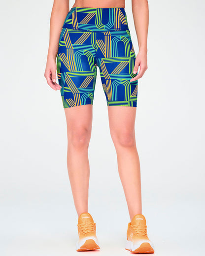 Female model in the blue retro striped-letter high-waisted biker shorts, showing the wide high waistband and above-the-knee length.