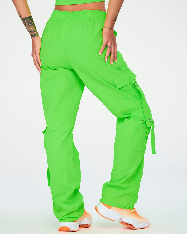 Back view of the neon green cargo pants with tassels, showing the side cargo pocket with a hanging tassel strap on the right leg.