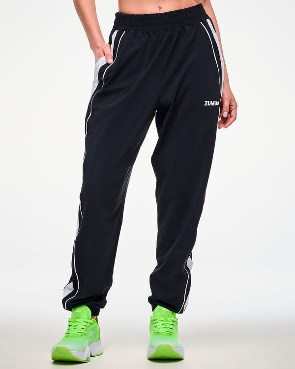 Female model wearing black joggers with a white side stripe, 