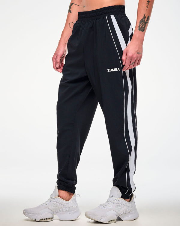 Male model wearing black joggers with a white side stripe, 
