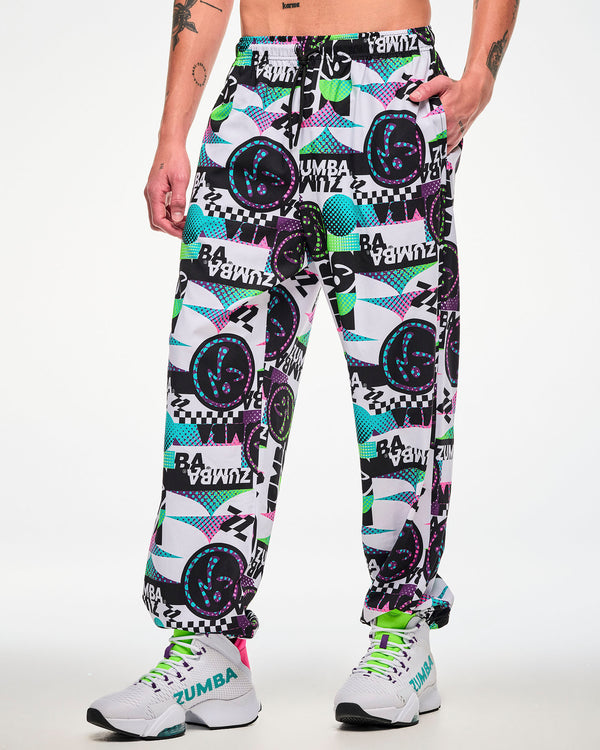Male model wearing white track pants with an all-over abstract pattern of shapes and Zumbito logos in black, aqua, pink, and green, and black and white 