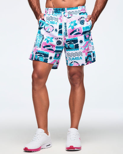 Front view of white elastic-waist drawstring shorts with a teal-and-pink Zumba graphic print and white drawcord; shown on a male model with white sneakers.