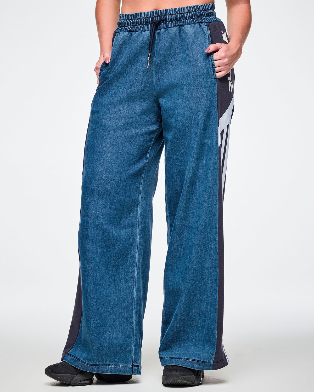 Close-up front view of a female model wearing wide-leg combo pants with an elastic drawcord waistband and navy side panel.