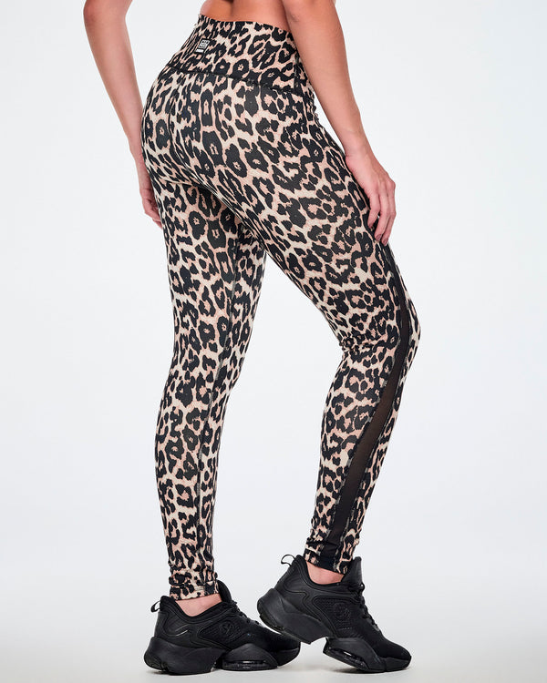 Back view of a female model wearing high-waisted leopard print leggings with sheer side panels, paired with black shoes.