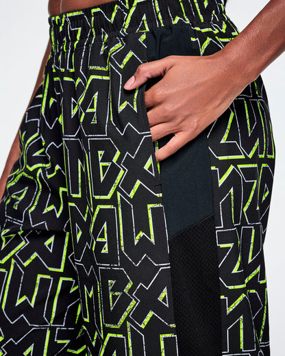 Close-up of a female model with her hand in the side pocket and showing the mesh side panel detail and the black Zumba text pattern, outlined in Zumba green.