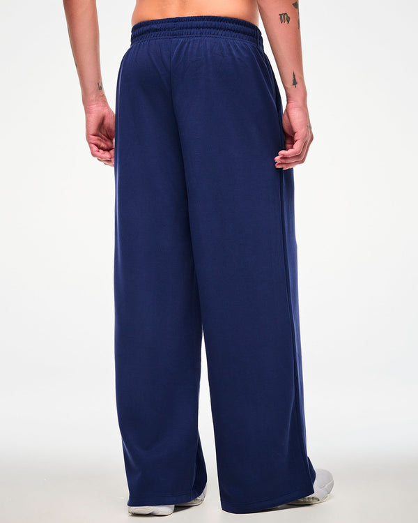 Back view of a male model in the navy straight-leg pants, showing the elastic waistband and full-length wide legs.