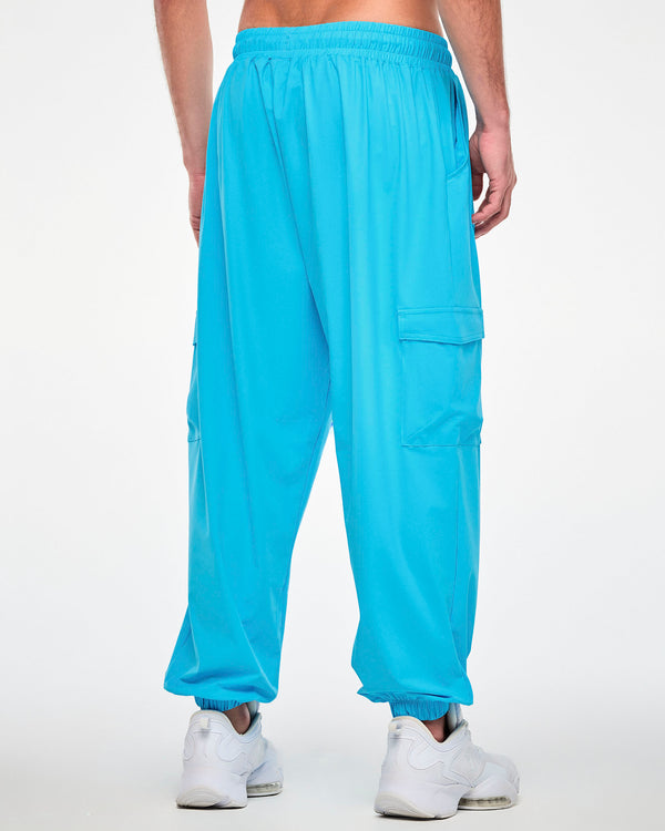 Back view of a male model in the aqua blue cargo pants, showing the gathered elastic waistband, a plain back, and a cargo pocket on each leg.