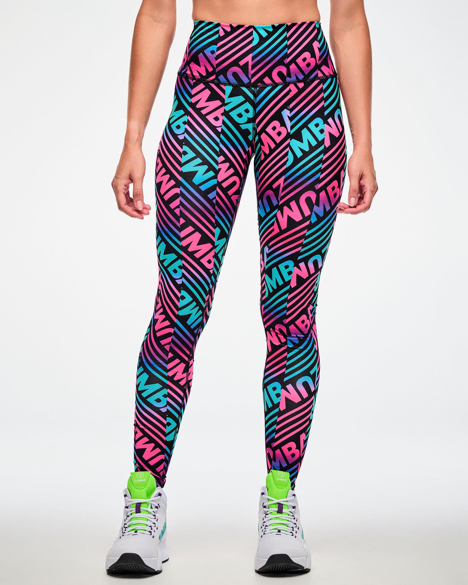 Female model wearing leggings with a bold pink, aqua, and black "ZUMBA" print.