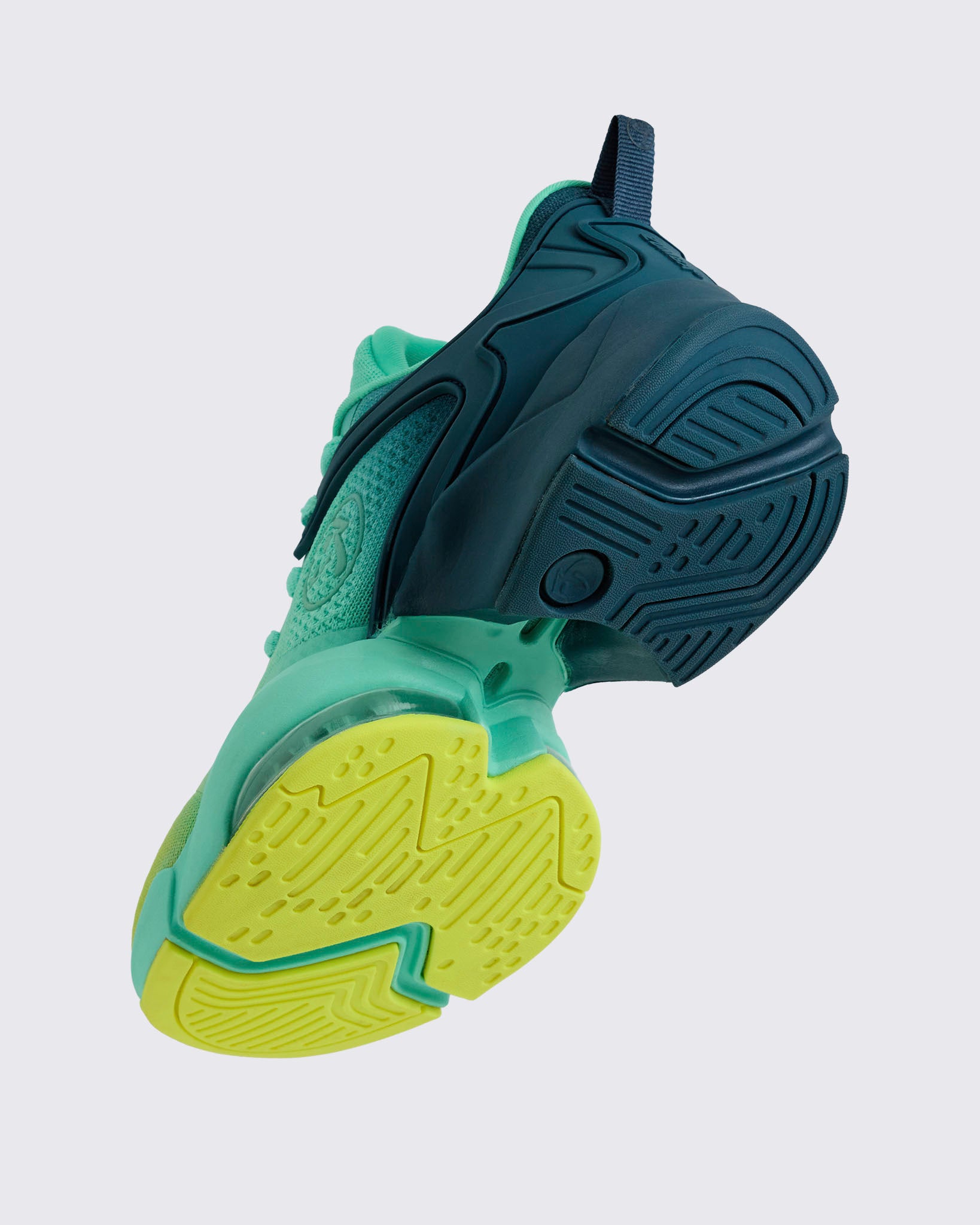 Angled side shot emphasizing the navy heel cage, mint midsole, clear air unit, and yellow toe outsole accents, on a light gray background.