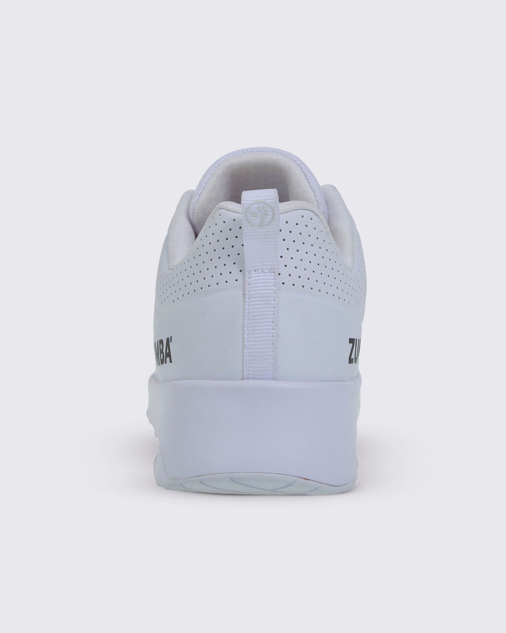 Back view of a white Zumba sneaker with the white pull-tag with the light silver Zumbito on it.