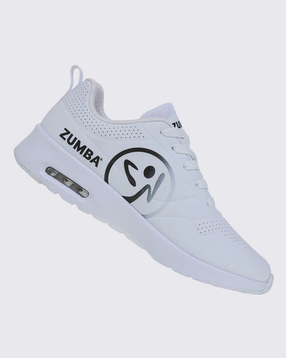 Right angled view of a white Zumba sneaker with a large black Zumbito and black Zumba text on a white background.