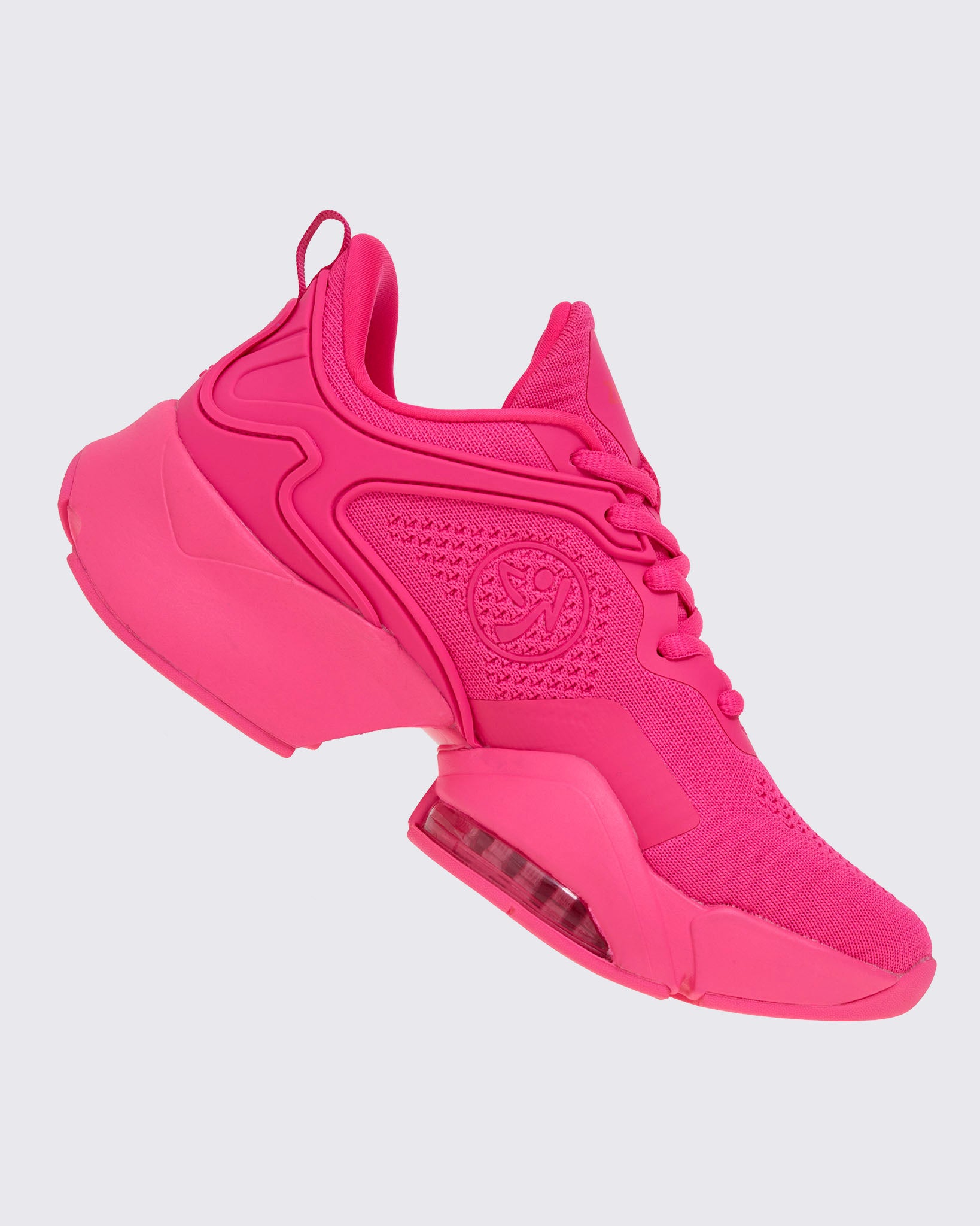 Right angled view of a pink shoe with a pink Zumbito on a white background.