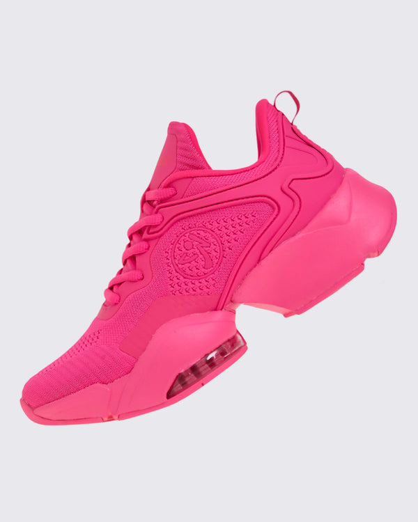 Left angled view of a pink shoe with a pink Zumbito on a white background.