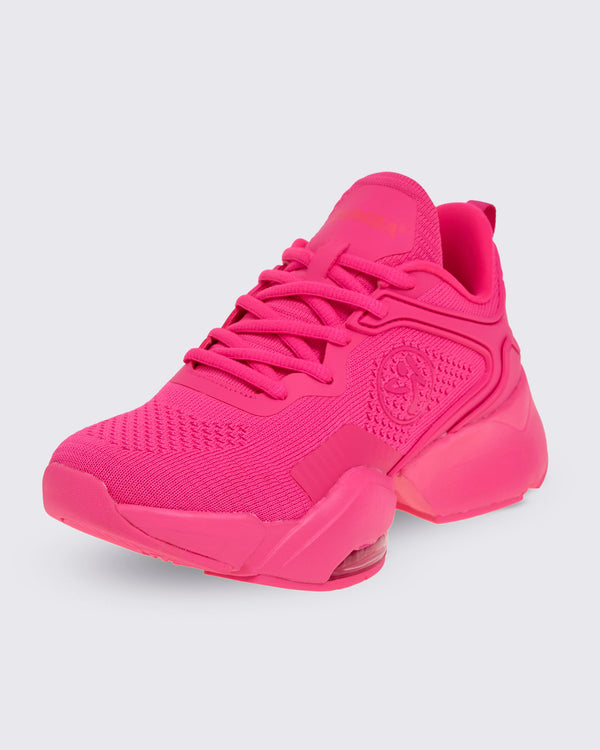 A pink shoe with a pink Zumbito on a white background.
