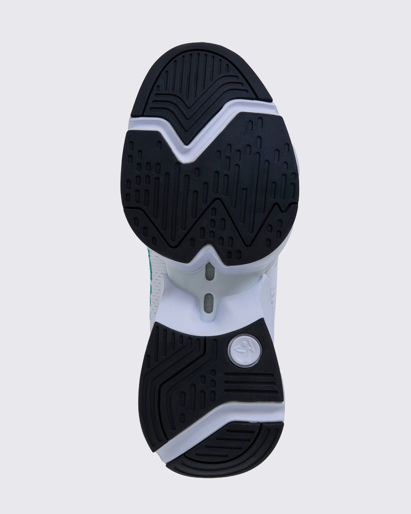 Sole view of a white sneaker's black rubber outsole with a Zumbito logo imprint and textured tread pattern.
