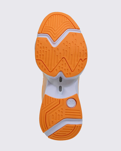 Sole view of the shoe, showing orange grooved tread split into forefoot and heel sections on a white sole, with a white Zumbito logo disc at the heel.
