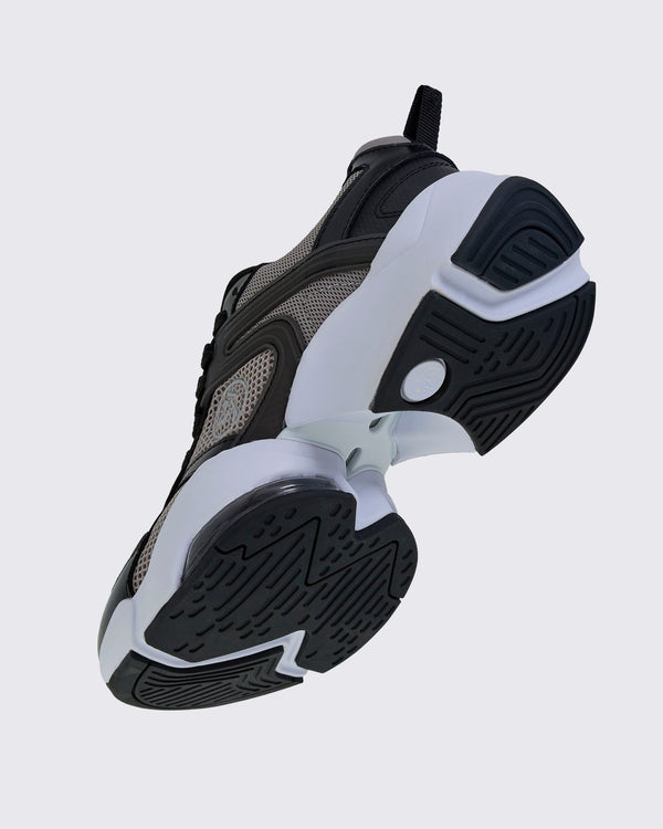 Angled underside view of the shoe, showing the black tread, a white sole with an open gap under the arch, and a clear air cushion near the toe.