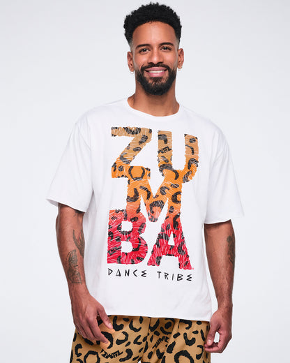 White oversized T-shirt with large multicolor “Zumba Dance Tribe” graphic lettering, shown on a smiling male model wearing tan leopard-print cargo pants.