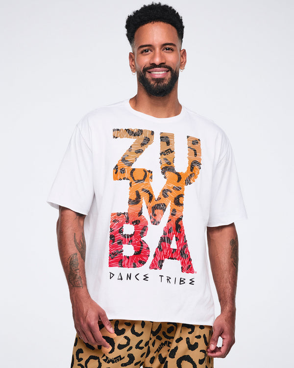 White oversized T-shirt with large multicolor “Zumba Dance Tribe” graphic lettering, shown on a smiling male model wearing tan leopard-print cargo pants.