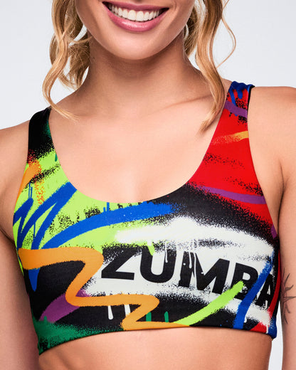 Colorful Zumba sports bra worn by a female model on a plain background.
