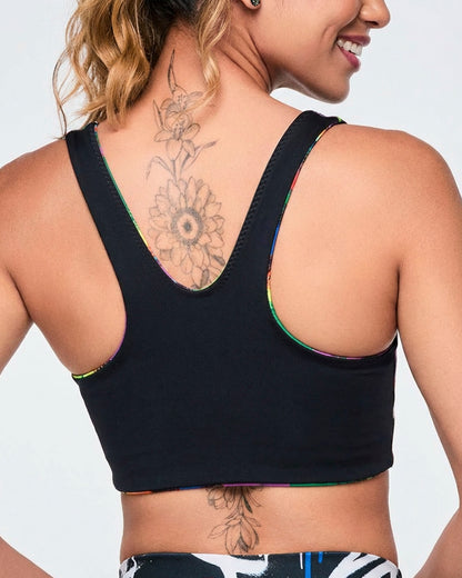Female model wearing a reversible bra, showing sold black with rainbow accents on a white background.