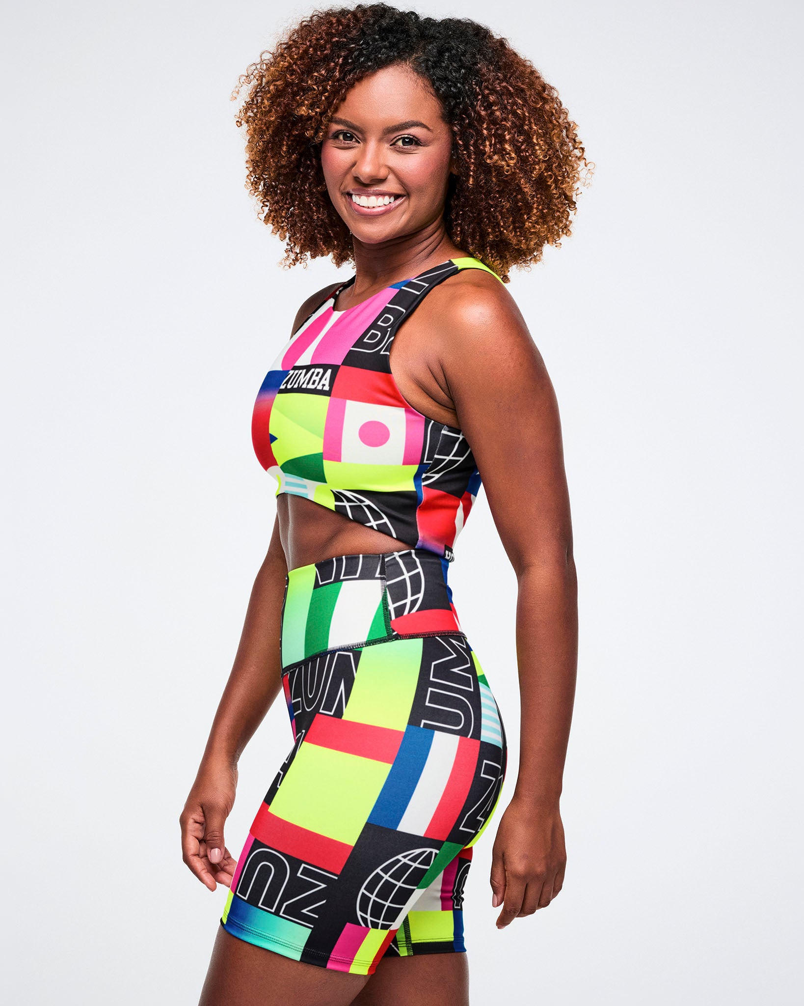 Female model wearing a colorful patterned outfit on a white background.