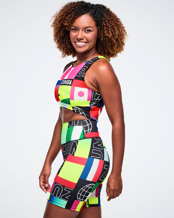 Female model wearing a colorful patterned outfit on a white background.