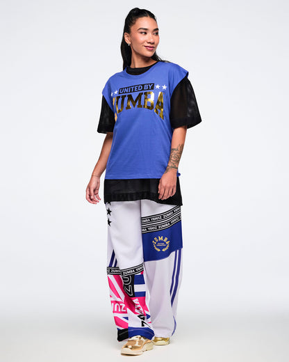 Female model wearing a blue and black outfit with 'Zumba' branding on a white background.