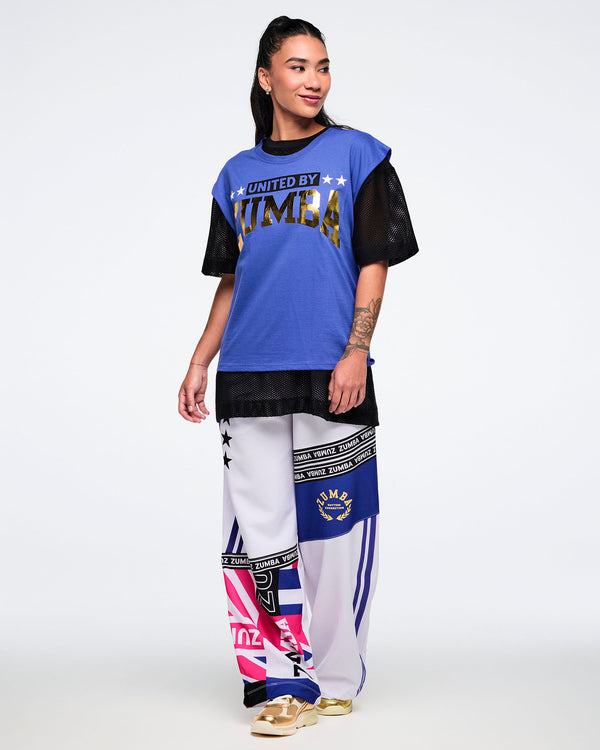 Female model wearing a blue and black outfit with 'Zumba' branding on a white background.